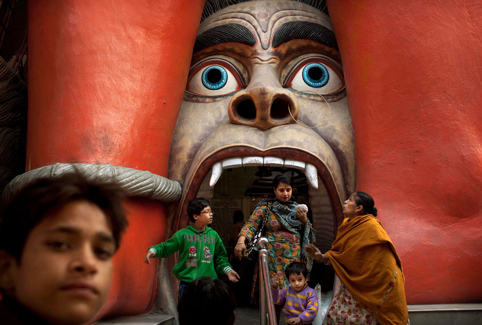 Индийская семья выходит из храма Ханумана в районе Карол Бегх в Нью-Дели. Бог-обезьяна Хануман – один из самых почитаемых божеств индуизма (AP Photo/Kevin Frayer)